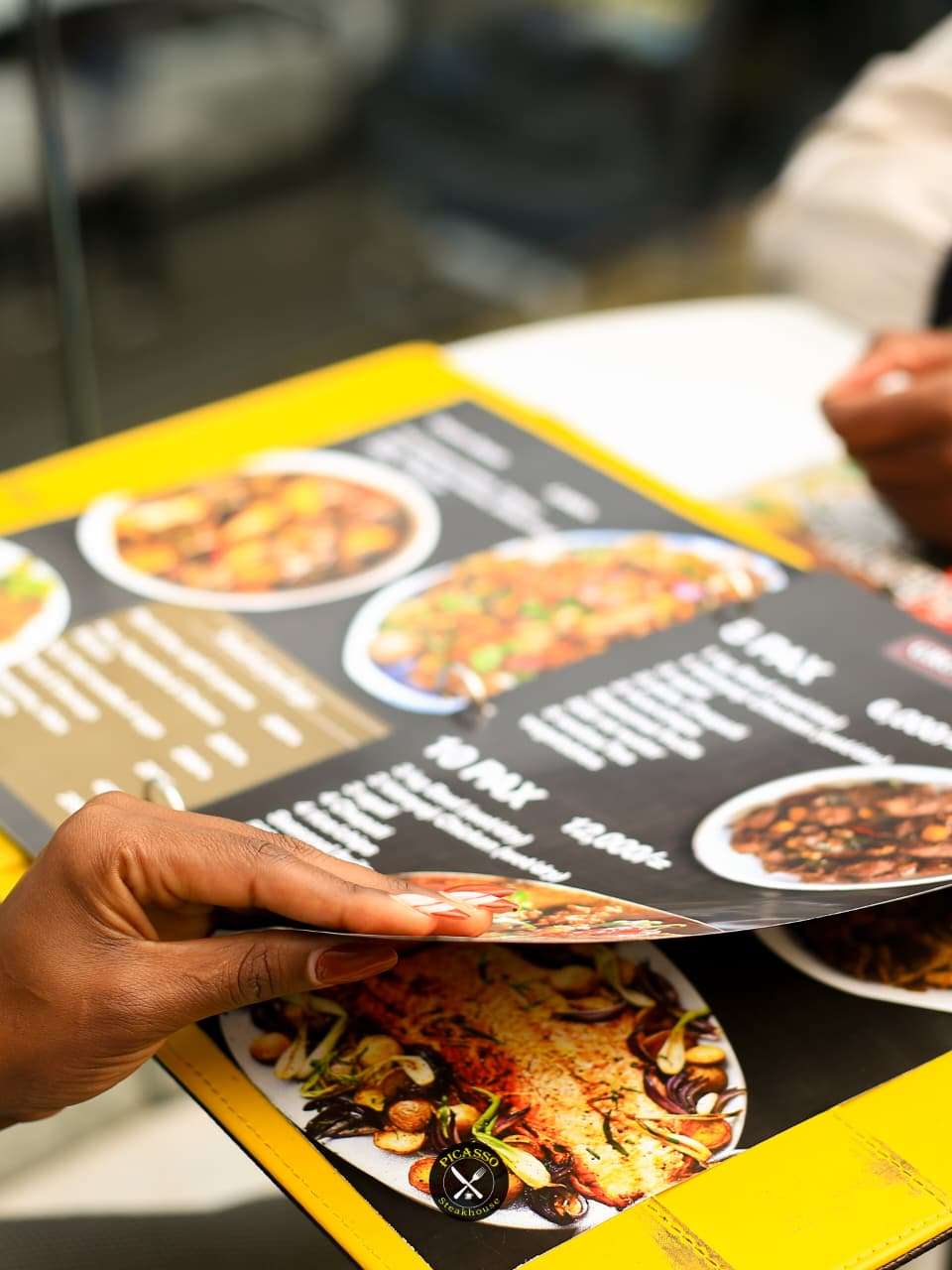 Customer browsing the menu at Picasso Steakhouse & Restaurants in Nairobi